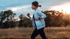 Is running cardio? Image shows young woman running in the park at sunset