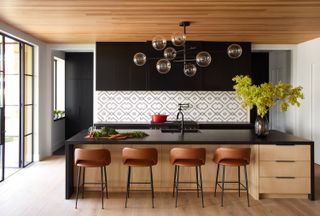 A kitchen with statement lighting above the island