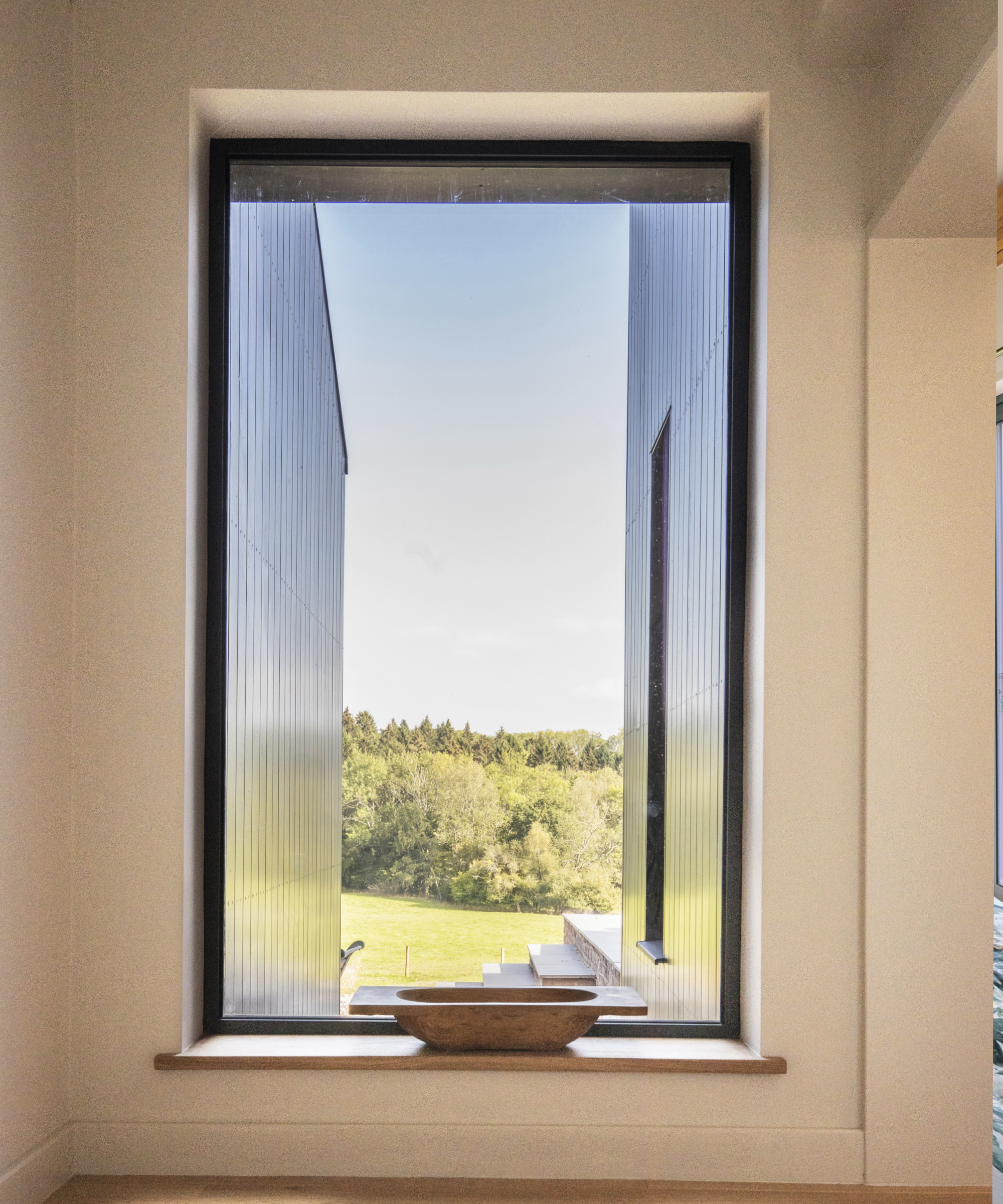 Large window with views of the garden and trees