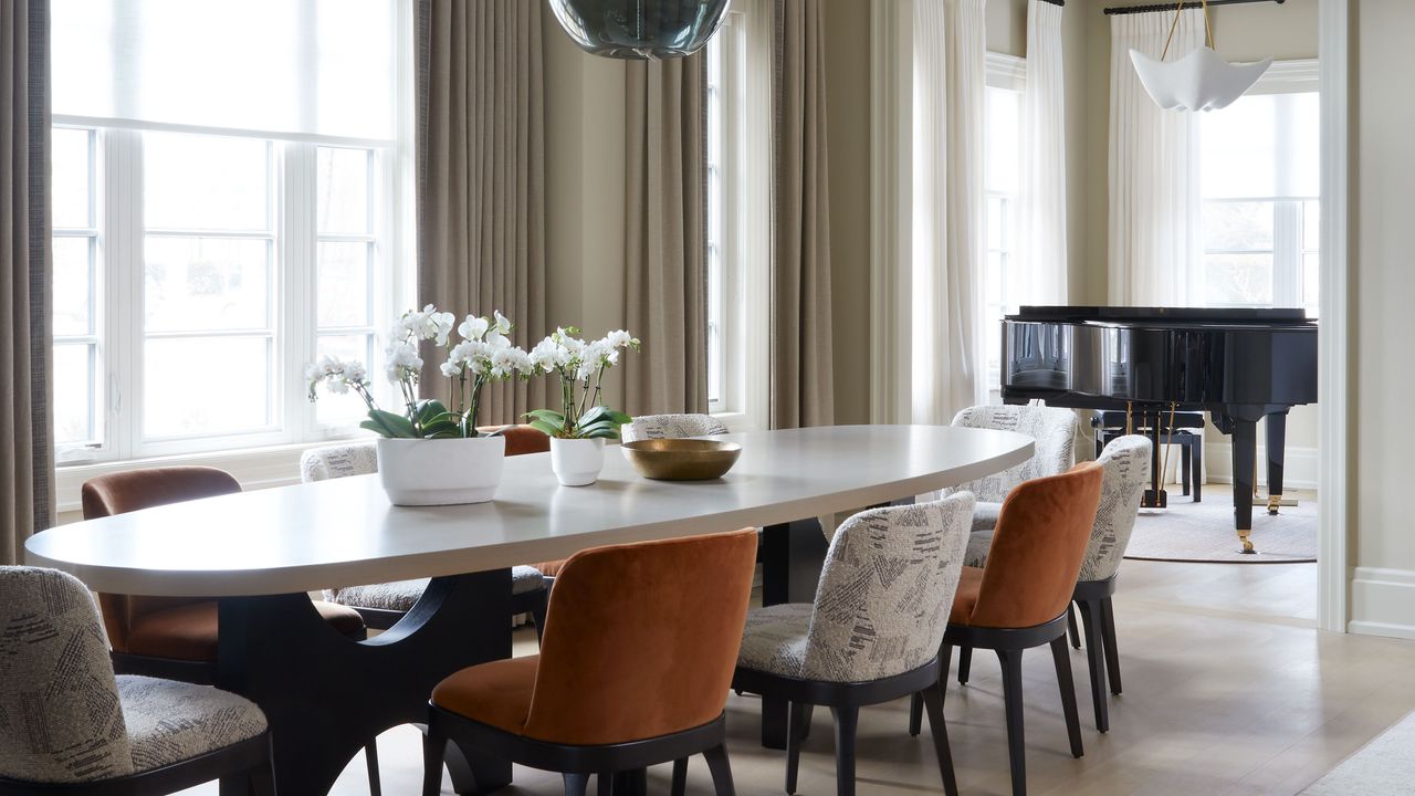 Modern dining room space with round pendant and flowers atop