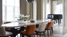 Modern dining room space with round pendant and flowers atop