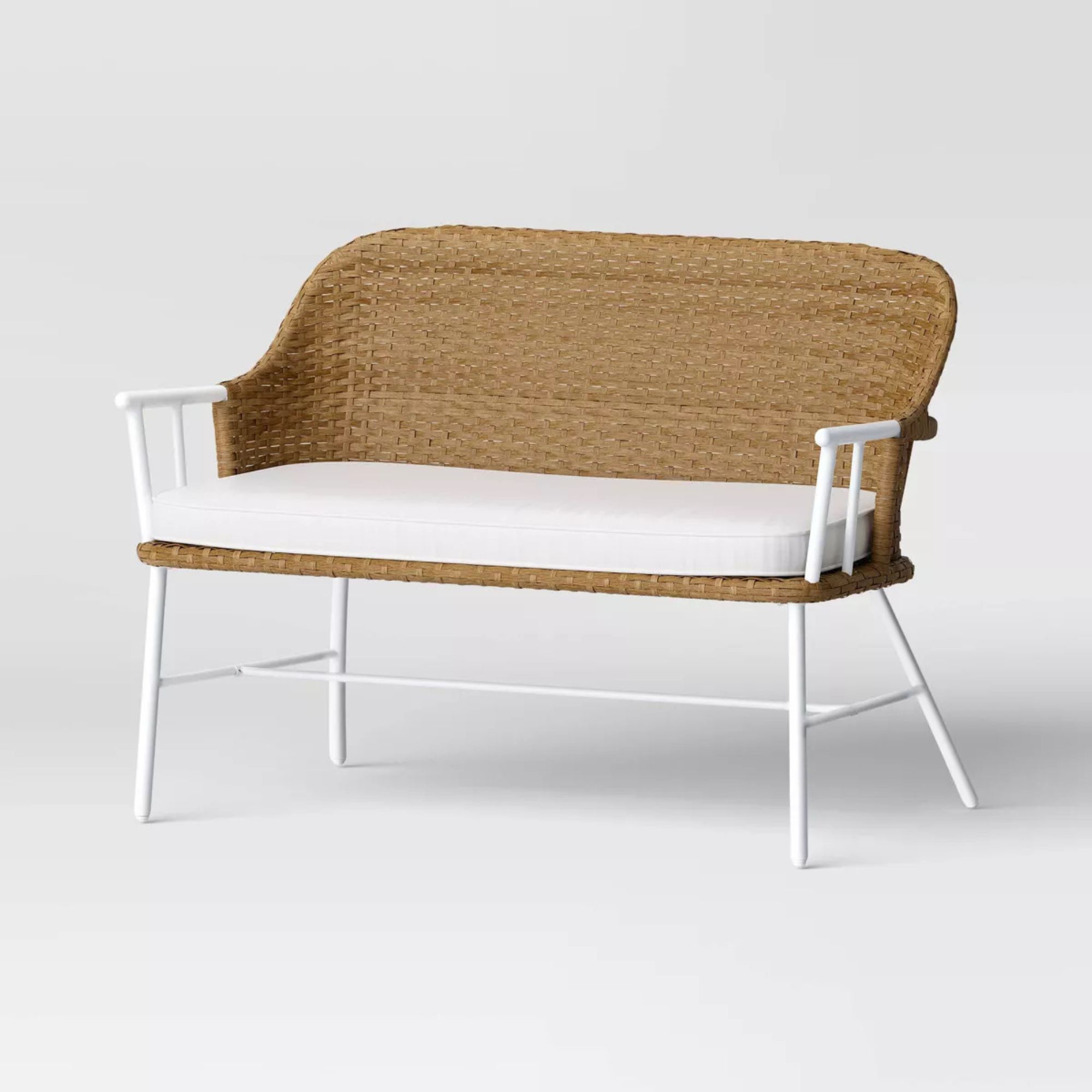 White and rattan outdoor bench with white bench pillow