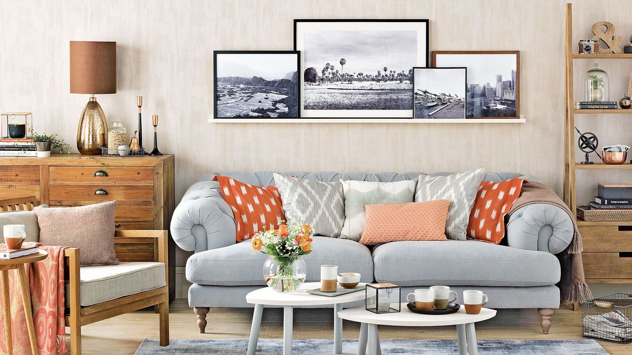 Living room with art prints displayed on a picture ledge above the grey sofa