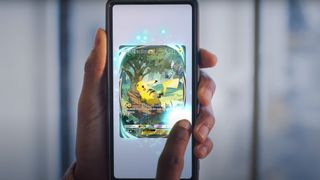 Someone taps on a glowing Pikachu EX card on their phone