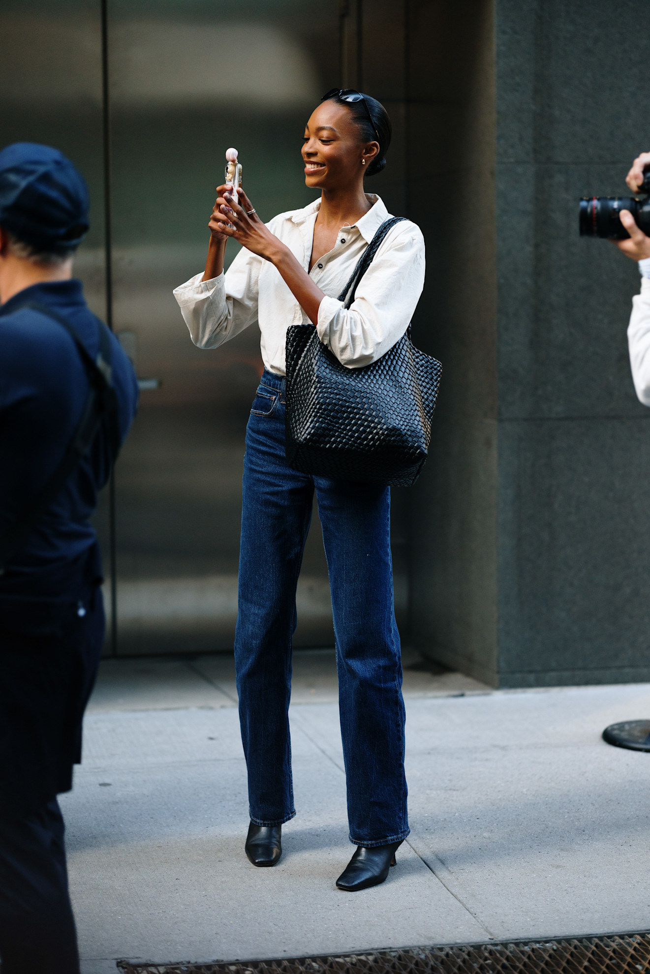 woman wearing white button-down, jeans, and black bag