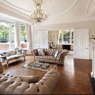 living room with button back sofa white walls and wooden flooring