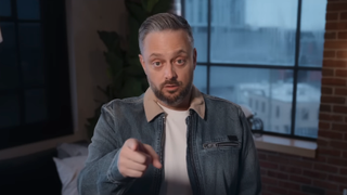 Nate Bargatze pointing to camera straight ahead while setting up the trailer for The Breadwinner 