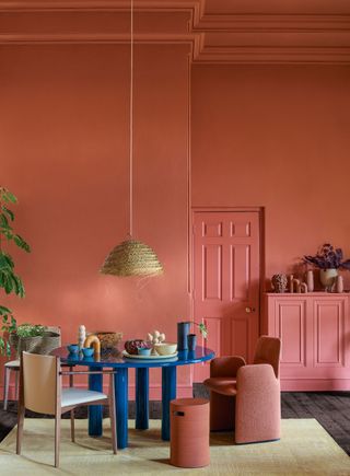 A salmon pink room scheme is broken up by a royal blue table