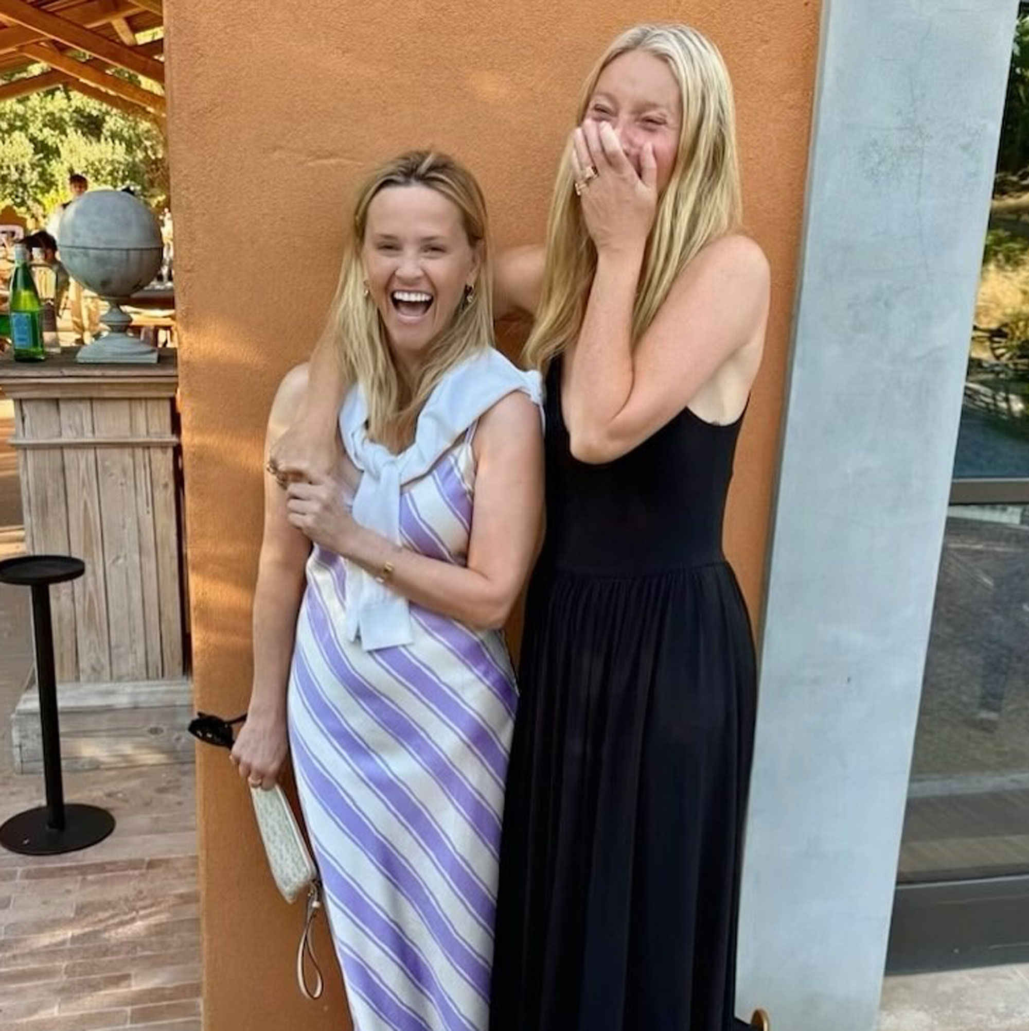 Gwyneth Paltrow wears a black dress and yellow sandals in a picture with Reese Witherspoon