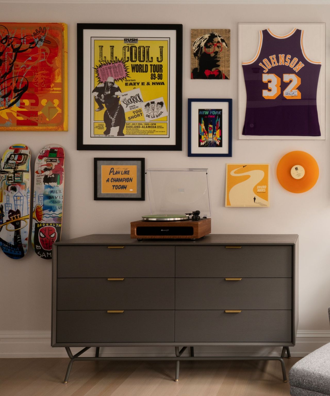 A gallery wall with bright colors, including a vinyl record, a basketball jersey, and two skateboards