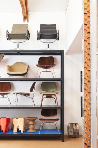Shelves with Eames designs, including chairs and wooden elephants