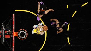 Alex Caruso #4 of the Los Angeles Lakers slam dunks the ball past Devin Booker #1 and Cameron Payne #15 of the Phoenix Suns during the second half of Game Two of the Western Conference first-round playoff series at Phoenix Suns Arena on May 25, 2021 in Phoenix, Arizona.