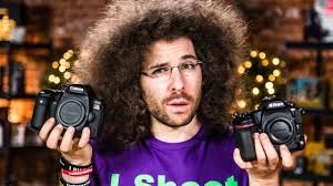 Jared Polin holding up two cameras