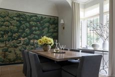 a dining room with storage covered in a woodland wallpaper mural