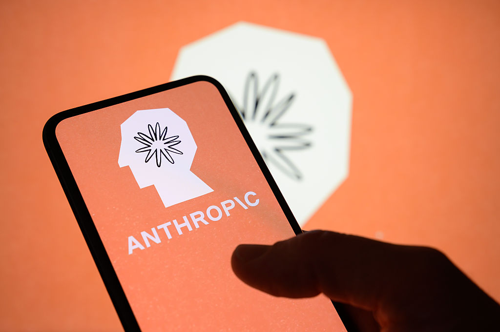 The Anthropic logo is displayed on the screen of a handheld smartphone