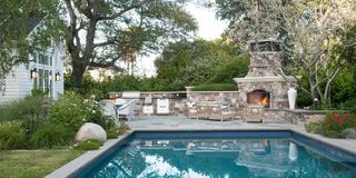 backyard with pool and entertaining area with a large outdoor fireplace