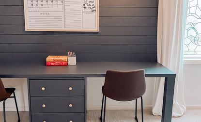 Teal blue built-in desk with black chairs and books on top