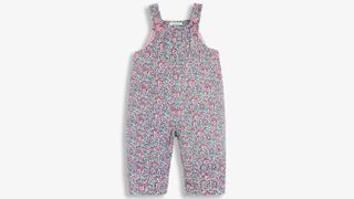 A floral ditsy print baby dungaree suit shot on a white background