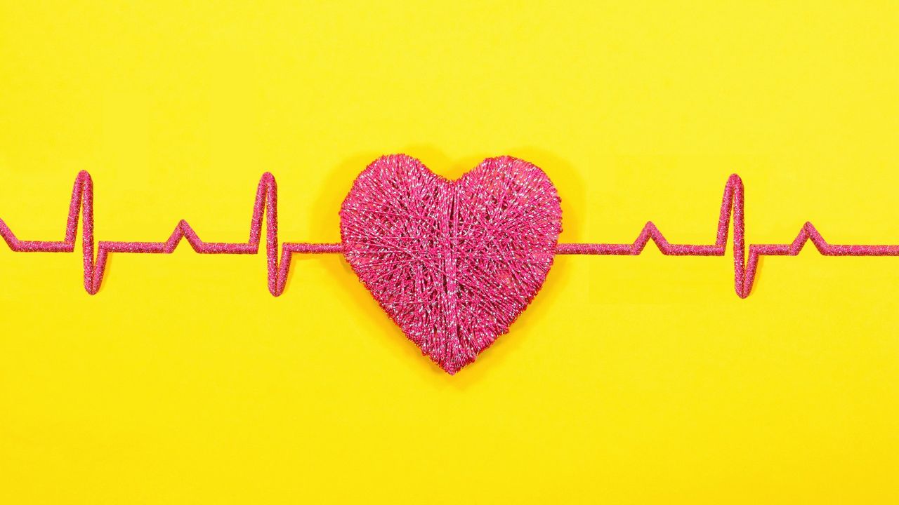 Red heart shape with heart beat readings on yellow background.