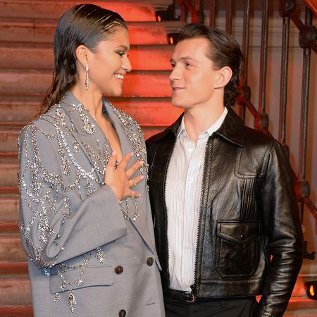 Zendaya in a bedazzled gray oversized blazer and Tom Holland in a button-shirt and fitted, black leather jacket at a Spider-Man photocall in London.