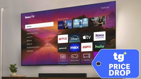 The Roku Pro Series, wall-mounted and displaying its home screen, next to a price tag-shaped badge that reads: "TG Price Drop"
