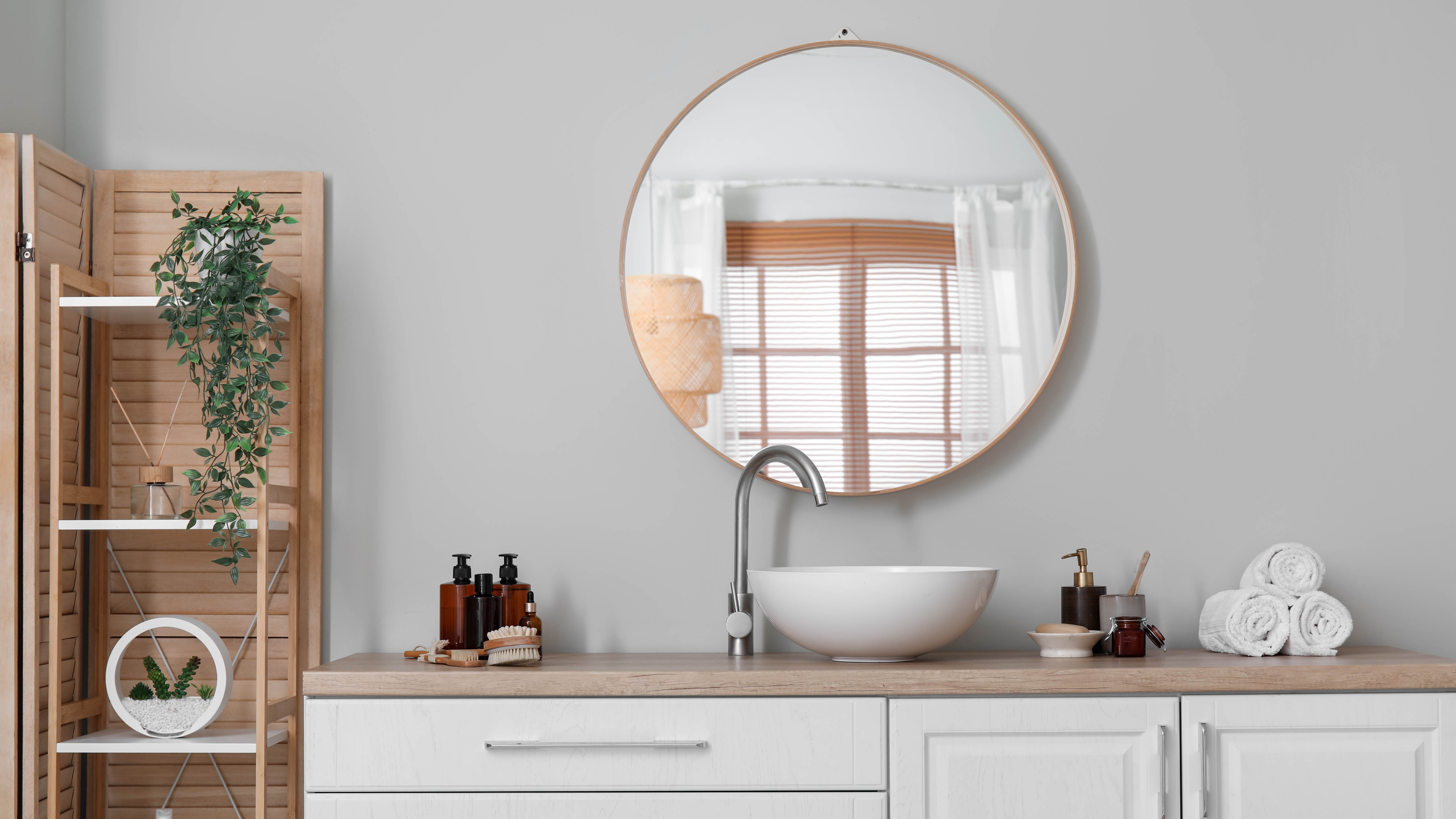 Круглое зеркало в ванной над раковиной