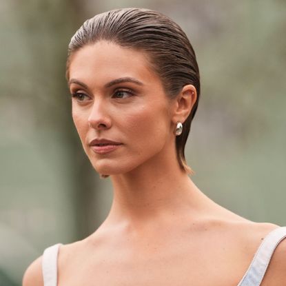woman with slicked back hair and bronzed skin