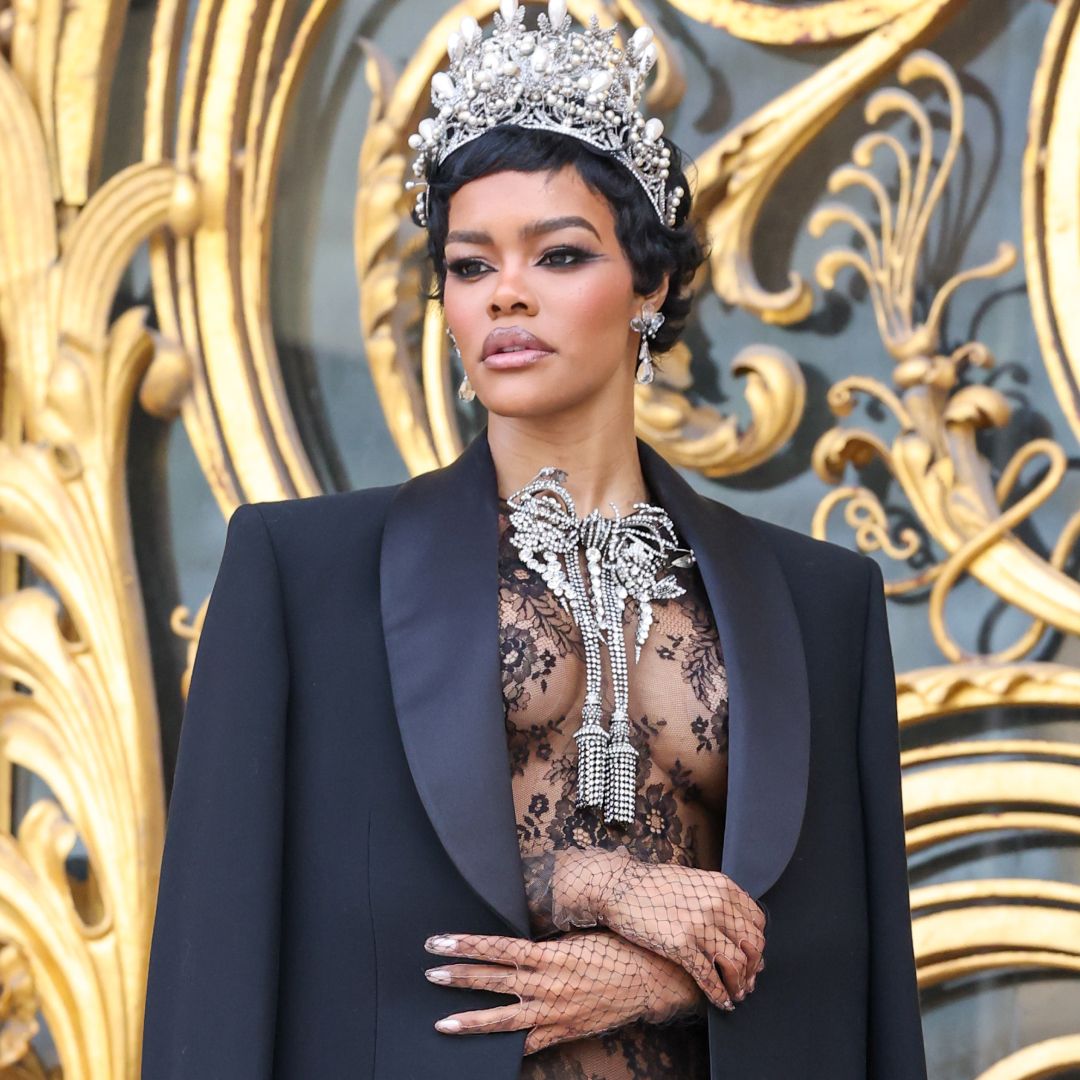 Teyana Taylor arrived at the Schiaparelli couture show in a lace little black dress, a crown, and a bow necklace inspired by her golden globes back