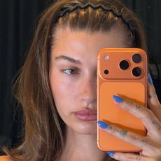 Hailey Bieber taking a selfie while wearing OPI Blue Them All Away nail polish