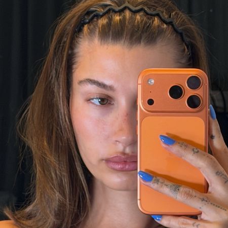 Hailey Bieber taking a selfie while wearing OPI Blue Them All Away nail polish