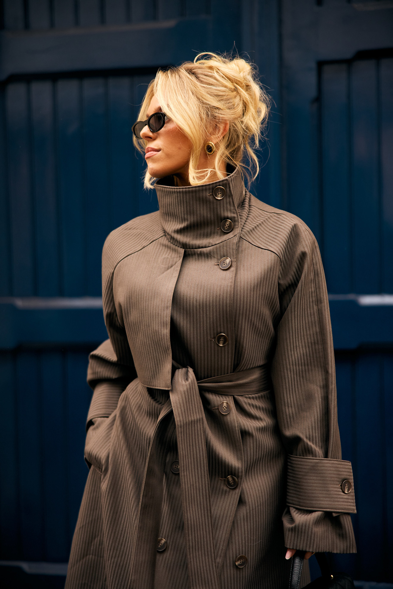 a blonde woman in a tan trench coat