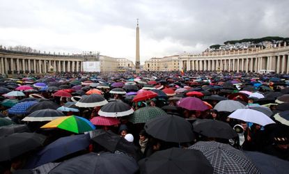 Devotees from across the globe, take shelter under umbrellas in St. Peter's Square, March 13.
