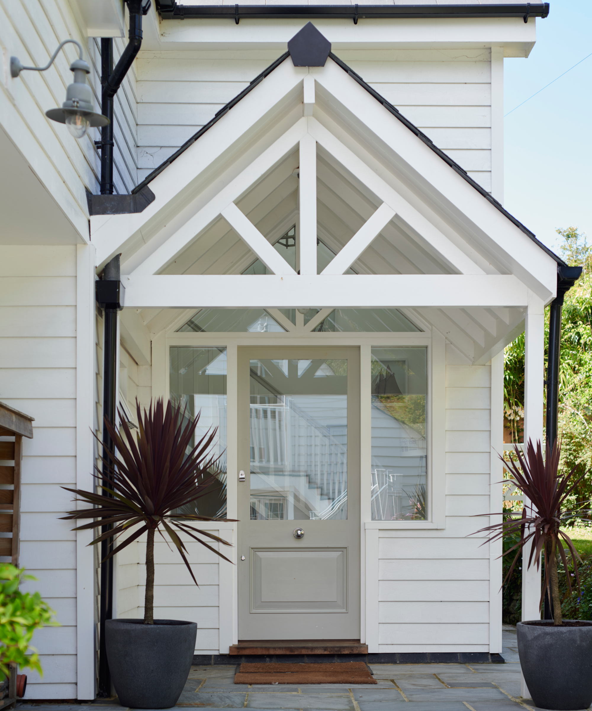 white wooden porch on white timber clad home