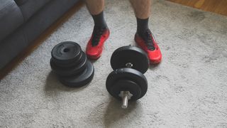 Man standing next to adjustable dumbbell