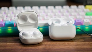 Samsung Galaxy Buds 2 Pro and AirPods Pro 2 in front of keyboard with cases open