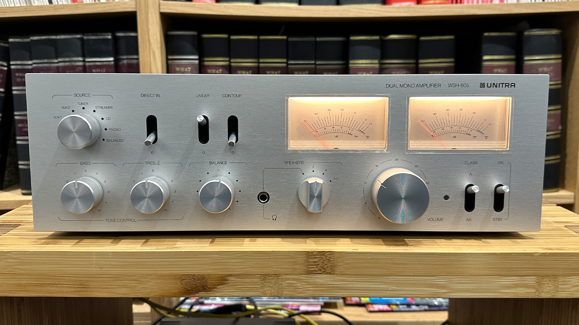 Unitra WSH-805 integrated amplifier on wooden hi-fi rack in front of bookcase