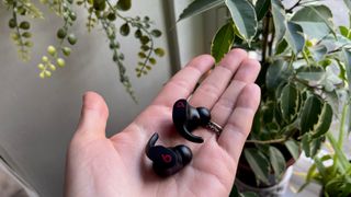 Beats Fit Pro earbuds in the palm of a hand