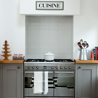 kitchen room with white wall and oven with cabinets