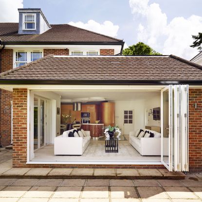 house with bifold glass door with wooden frame in white colour 