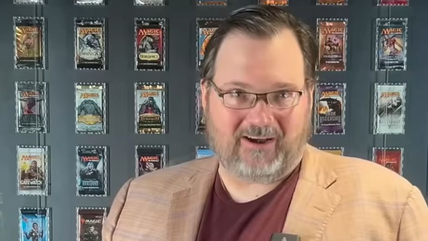 Brandon Sanderson in front of multiple MTG booster packs