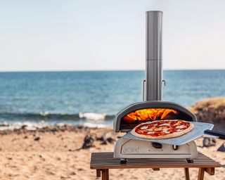 An Ooni pizza oven set up on the beach