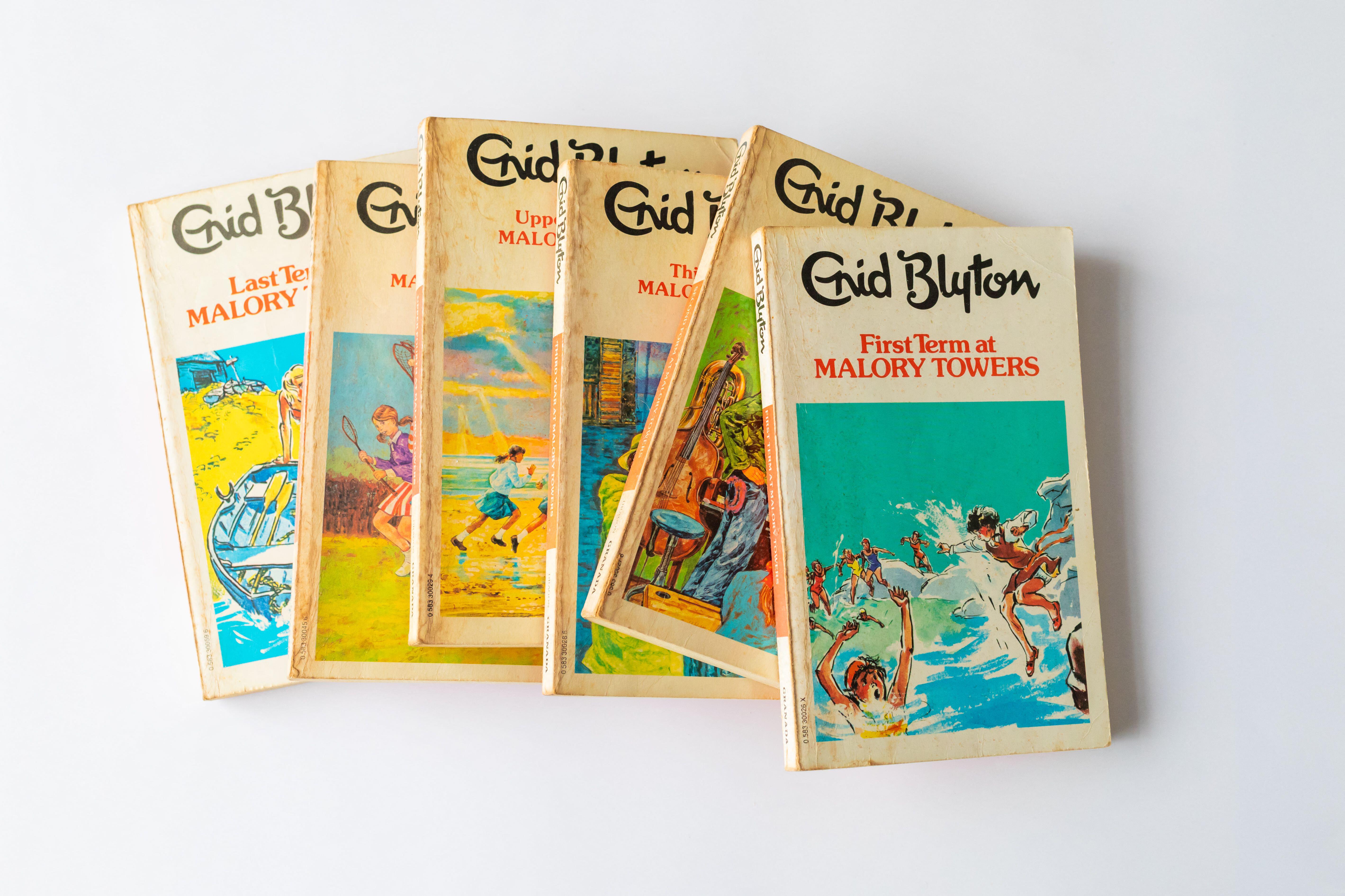 Pile of vintage Enid Blyton books on a white background