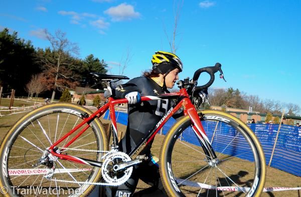 Crystal Anthony (Ladies First Racing) lifts her bike high over the barriers