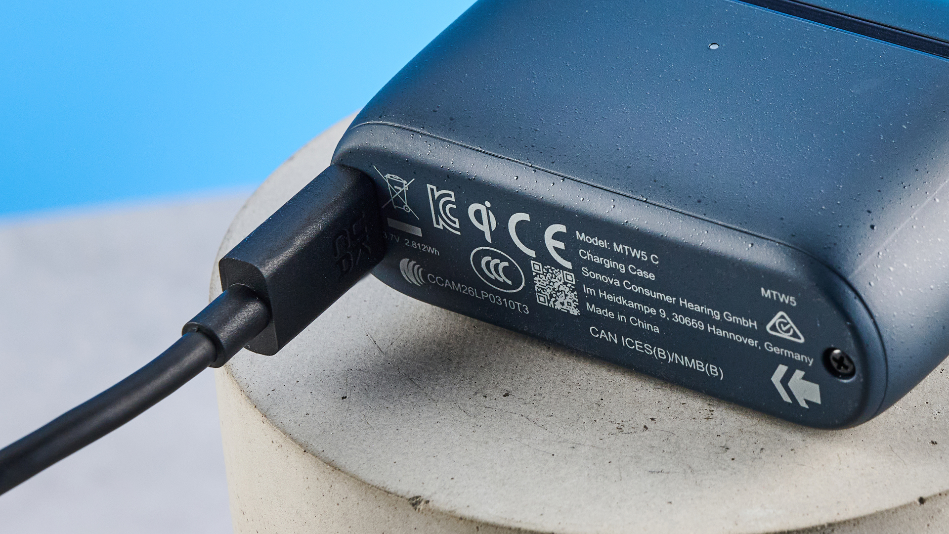 the sennheiser momentum 5 true wireless earbuds in navy photographed with the blue tom's guide background