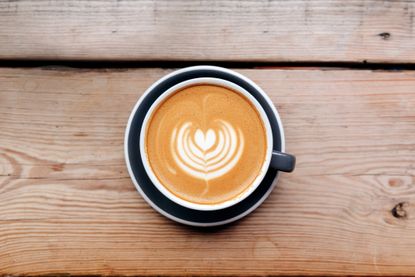 looking down onto a coffee in a mug on a wooden table