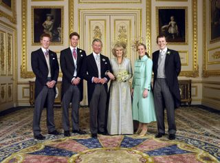 Prince Harry, Prince William, King Charles, Queen Camilla, Laura Lopes and Tom Parker Bowles posing in suits and dresses for a formal wedding portrait at Charles and Camilla's wedding