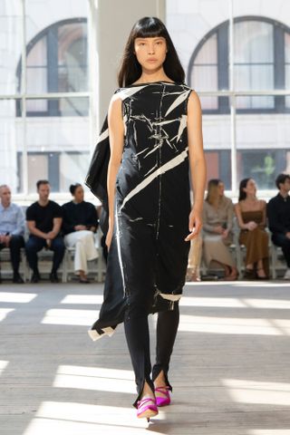 A Proenza Schouler model walks the spring/summer 2025 runway in split-hem trousers