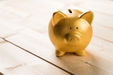 gold piggy bank on hardwood floors