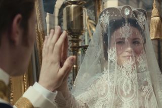 Elisabeth (Devrim Lingnau), face covered by a veil, holds her hand up to Franz's (Philip Froissant) hand, in 'The Empress.'