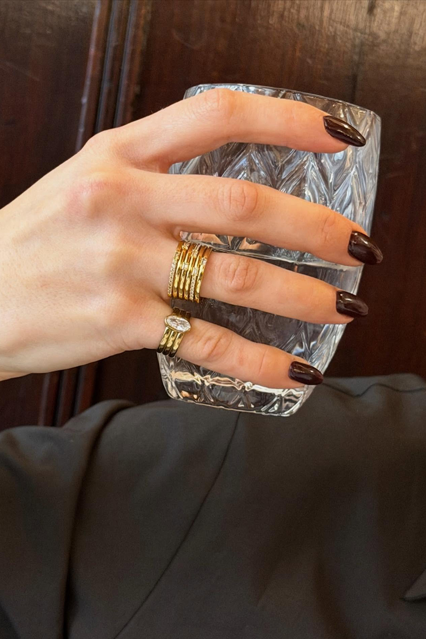 a woman wearing a gold pinky ring